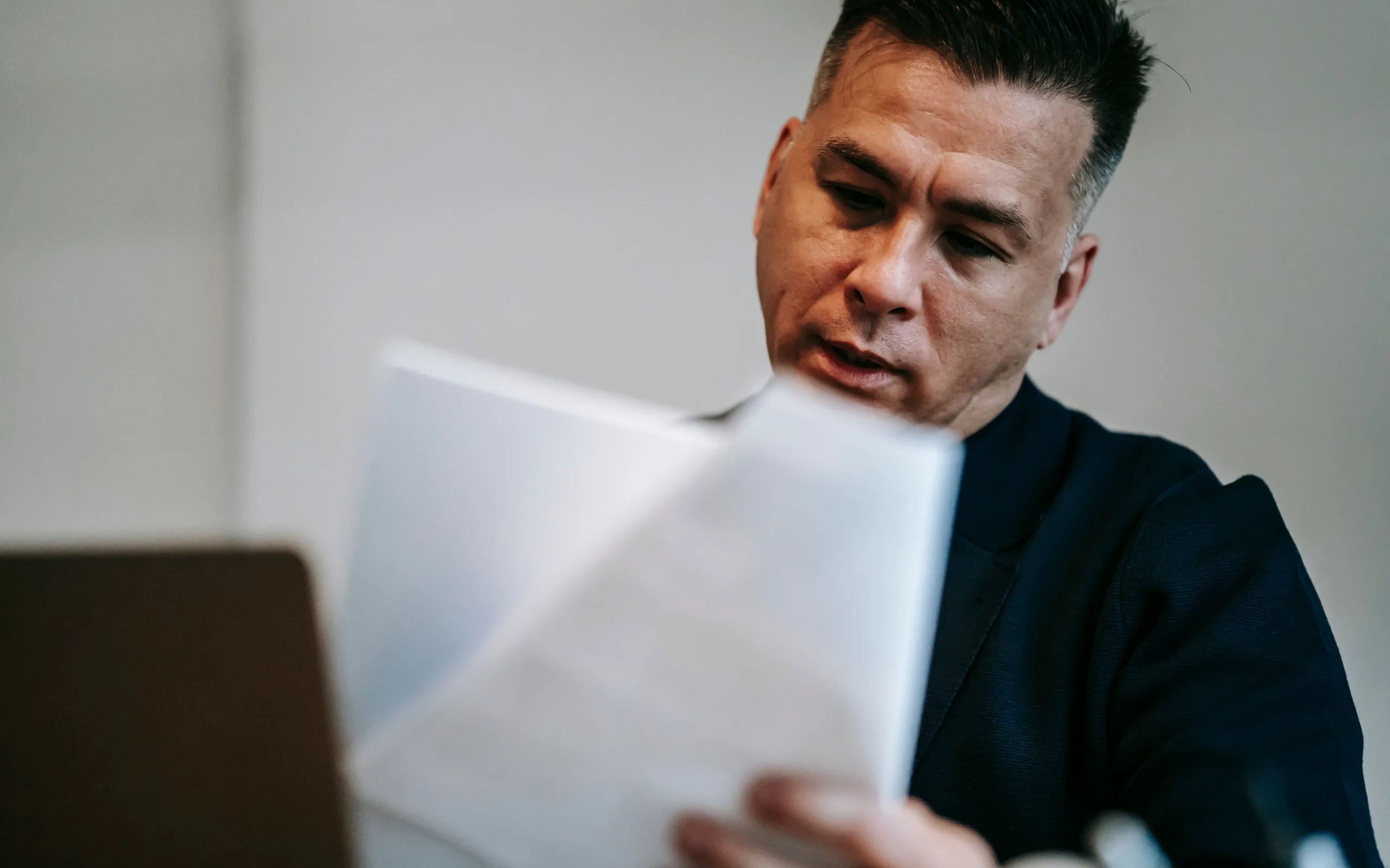 Professionnel relisant attentivement des documents à son bureau